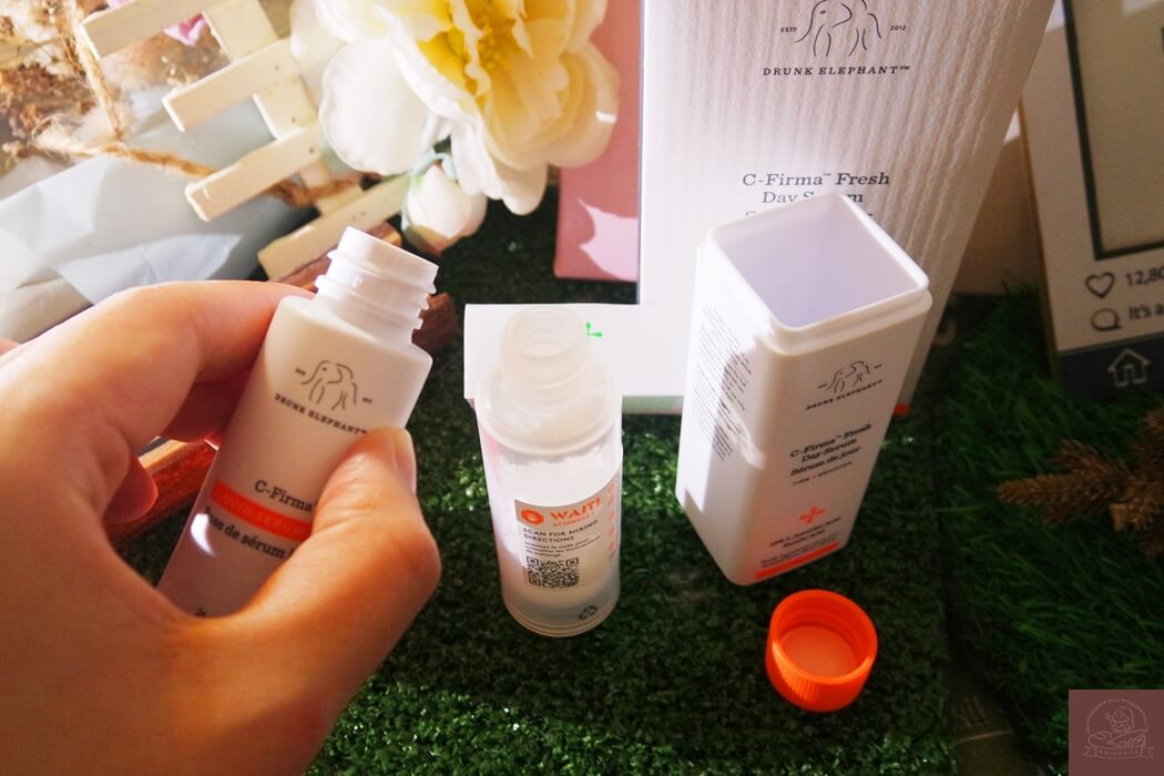 將維他命 C 粉末的瓶身壓頭拿起來後開始倒入精華液